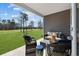 Cozy covered patio showcasing outdoor furniture, a lush green lawn, and a view of the golf course at 1705 Seachase Way, North Myrtle Beach, SC 29582