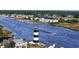 Scenic view of a black and white lighthouse along the waterway, with boats and waterfront homes visible at 1713 Seachase Way, North Myrtle Beach, SC 29582