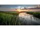 Sun setting with colorful sky reflecting over the water and tall marsh grasses at 1713 Seachase Way, North Myrtle Beach, SC 29582