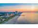 Stunning aerial view of a coastline with sandy beach, pier, and skyline at sunset at 1717 Seachase Way, North Myrtle Beach, SC 29582