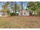 Back view of a single-story home surrounded by large trees and lush landscaping at 177 Reef Run Rd., Pawleys Island, SC 29585