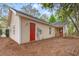 Home featuring beige siding, red doors, and a well-kept yard with natural foliage at 177 Reef Run Rd., Pawleys Island, SC 29585