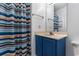 This cozy bathroom features a blue vanity cabinet, a shower, and colorful stripes at 1851 Fairway Ridge # 7C, Surfside Beach, SC 29575