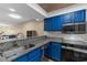 Well-equipped kitchen featuring blue cabinetry, stainless steel appliances, and granite counters at 1851 Fairway Ridge # 7C, Surfside Beach, SC 29575