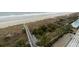 Great aerial view of community boardwalk giving beach access plus palm tree landscaping at 1903 S Ocean Blvd. # 606, North Myrtle Beach, SC 29582