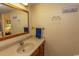 Neutral bathroom with wood cabinets, beige countertops, large mirror and beach-themed decor at 2001 S Ocean Blvd. # 418, Myrtle Beach, SC 29577