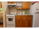 Galley-style kitchen with wood cabinets, white appliances, and a window at 2001 S Ocean Blvd. # 418, Myrtle Beach, SC 29577