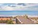 A scenic beach view, showcasing buildings, palm trees, and a glimpse of a pool under a cloudy sky at 201 75Th Ave N # 4094, Myrtle Beach, SC 29572