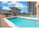 Large outdoor pool with lounge chairs and umbrellas surrounded by lush landscaping and the condo buildings at 201 75Th Ave N # 4094, Myrtle Beach, SC 29572