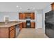 Kitchen with brown cabinets, black appliances, tile flooring, and a granite countertop at 228 Gresham Ln., Myrtle Beach, SC 29588