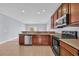 A functional kitchen with stainless steel appliances, tile flooring, and brown cabinets at 228 Gresham Ln., Myrtle Beach, SC 29588