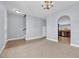 Open living room leading to the kitchen with neutral carpet and arched doorway at 228 Gresham Ln., Myrtle Beach, SC 29588