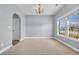 Well-lit living room with a large window, neutral carpet, and arched doorway at 228 Gresham Ln., Myrtle Beach, SC 29588