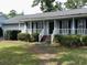 Inviting home featuring a classic white-railed front porch and well-manicured lawn at 228 Lander Dr., Conway, SC 29526