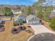 An aerial view showing the home's landscaping, three-car garage, and proximity to a pond and woods at 229 Duchess Ct., Myrtle Beach, SC 29588