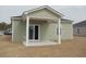 Backyard view featuring a covered porch area with sliding glass door access into the home at 255 Warner Crossing Way, Loris, SC 29569