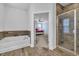 Open bathroom featuring a soaking tub, glass shower, and view of the bedroom through the doorway at 2593 Pegasus Place, Myrtle Beach, SC 29577
