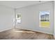 Bright bedroom with wood-look floors and two windows overlooking the backyard at 272 Warner Crossing Way, Loris, SC 29569