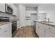 Modern kitchen with white cabinets, granite countertops, stainless steel appliances, and wood grain floors at 272 Warner Crossing Way, Loris, SC 29569