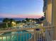 An elevated view of an outdoor pool and deck at dusk, with beach and palm trees in the background at 2801 S Ocean Blvd. # 733, North Myrtle Beach, SC 29582