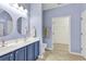 Blue bathroom featuring double sinks, tile floors, and access to walk-in closet at 300 Nuthatch Ln. # A, Murrells Inlet, SC 29576