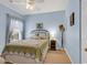 Blue bedroom with a patterned quilt, window with curtains, and bedside table with lamp at 300 Nuthatch Ln. # A, Murrells Inlet, SC 29576