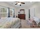 Sunlit bedroom featuring a large window, wood dresser and a patterned quilt on bed at 300 Nuthatch Ln. # A, Murrells Inlet, SC 29576