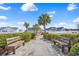 Scenic community walkway featuring inviting benches, lush landscaping, and palm trees on a sunny day at 3124 Ivy Lea Dr., Conway, SC 29526