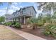 Charming two-story blue home featuring a cozy front porch and lush landscaping at 317 14Th Ave. N, Surfside Beach, SC 29575