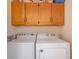 Functional laundry area featuring a side-by-side washer and dryer, with upper wooden cabinets for storage at 317 14Th Ave. N, Surfside Beach, SC 29575