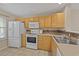 Bright kitchen with wood cabinets, white appliances, tile flooring, and ample countertop space at 3524 Crepe Myrtle Ct. # 3524, Myrtle Beach, SC 29577