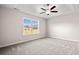 Bedroom featuring tray ceilings, ceiling fan, neutral paint, plush carpet, and a large window offering neighborhood views at 375 West Dogwood Rd., Loris, SC 29569