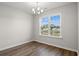 Well-lit dining room with hardwood floors, a modern chandelier, and a large window view at 375 West Dogwood Rd., Loris, SC 29569