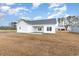 A newly constructed home features a spacious backyard under a partly cloudy blue sky at 379 West Dogwood Rd., Loris, SC 29569