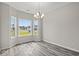 Bright dining area features large windows, wood-look floors, and stylish chandelier at 379 West Dogwood Rd., Loris, SC 29569