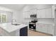 Modern kitchen featuring white cabinets, stainless steel appliances, quartz countertop, and hardwood flooring at 383 West Dogwood Rd., Loris, SC 29569