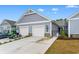 Light gray townhome with white garage doors, brick accents, and manicured landscaping at 4027 Taranto Loop # 3203-C, Myrtle Beach, SC 29579