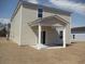 A home featuring light beige vinyl siding and a covered patio at 444 Ribbon Rail Way, Loris, SC 29569