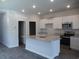 A modern kitchen with white cabinets, a granite island, stainless steel appliances, and wood floors at 444 Ribbon Rail Way, Loris, SC 29569