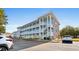 Three-story condo building with pale blue siding, white stairs and railings, and stone accents on a sunny day at 4655 Wild Iris Dr. # 101, Myrtle Beach, SC 29577