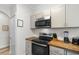 Kitchen area featuring stainless steel microwave and oven, butcher block countertops, and gray cabinets at 4655 Wild Iris Dr. # 101, Myrtle Beach, SC 29577