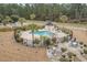 Aerial view of a community pool with palm trees, lounge chairs, and landscaping at 4870 Dahlia Ct. # 304, Myrtle Beach, SC 29577