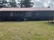 Brick home exterior showcasing a red roof, windows, and a grassy backyard with mature trees at 51 Cleburn St., Georgetown, SC 29440