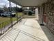 Spacious covered front porch with metal railing and a concrete floor overlooking the front yard at 51 Cleburn St., Georgetown, SC 29440