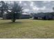 View of the property with a brick home, lawn, shed, and mature trees on a cloudy day at 51 Cleburn St., Georgetown, SC 29440