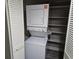 A laundry closet with a stackable washer and dryer and shelving at 5200 N Ocean Blvd. # 151, Myrtle Beach, SC 29577