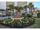 Resort entrance with palm trees and a flower garden, plus a resort sign at 5200 N Ocean Blvd. # 155, Myrtle Beach, SC 29577