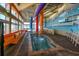 This indoor pool includes a smaller pool or hot tub for relaxation, surrounded by colorful artwork and lounge chairs at 5200 N Ocean Blvd. # 155, Myrtle Beach, SC 29577