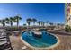 Relaxing waterfront pool area with lounge chairs and palm trees at 5200 N Ocean Blvd. # 155, Myrtle Beach, SC 29577