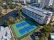 Aerial view of community tennis and basketball courts next to a calm pond at 5200 N Ocean Blvd. # 155, Myrtle Beach, SC 29577